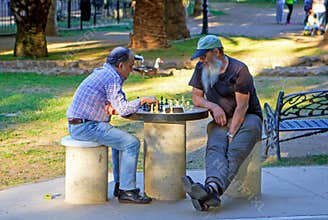Nice weather to play a game of chess in the park in the evening.