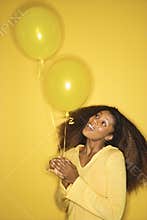 African-American woman holding balloons.