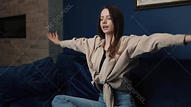 Young woman taking a deep breath whilst meditating in her living room lotus pose yoga relaxation