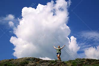Solitary smiling girl  holds in hands a cloud in mountains of Altai