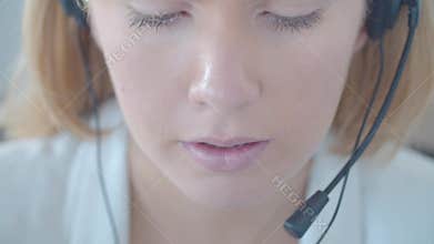 Face of young female call center operator in headset