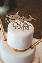 Vertical shot of a white cake with a plane and Mr and Mrs text