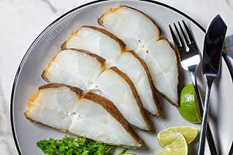 Halibut fish slices on a plate, top view