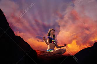 Silhouette of yoga of woman practising outdoors in mountains on a sunset