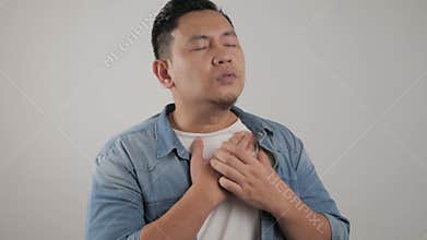 Young Asian man wearing suffer from chest pain. Heart attack or asthma