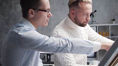 Architect and his colleague work in loft using drawing board and computers. Workplace of civil engineer in modern office