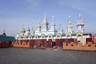 Selling of gobelins and rugs in Izmailovo Vernissage with eastern style building on background.