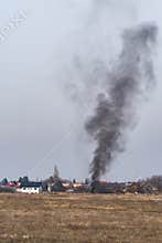 Black Smoke Rising to the Grey Winter Sky