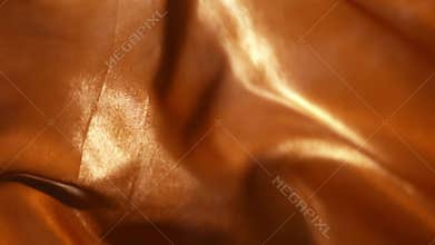 Orange gold textile is trembling on a wind in close-up and slow motion