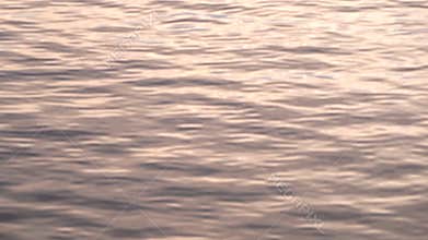 Natural water surface texture made in the evening or morning with sun reflection on waves. Calming abstract background