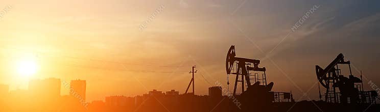 Oil rocking chairs on the background of the sunset sky