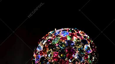 Close up of amazing luxury brooch with many colorful shiny gems. Concept. Rotating jewelry shining under spotlights