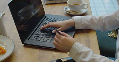 Female hand holding credit card and shopping online. Easy pay using digital gadget. Girl using laptop in cafe. Happy