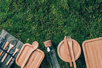 Fabric bags, glass jars, metal straws, bamboo cutlery on green grass, moss background. Eco friendly and reuse concept