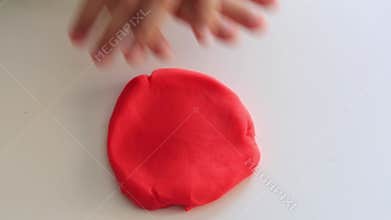 Child's hands playing colorful clay on table. Development of fine motor skills of fingers and creativity, education
