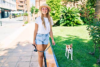 Young beautiful blonde woman walking the dog outside on a summer day