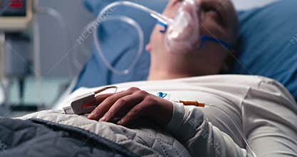 Patient with pulse oximeter lying on hospital bed