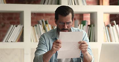 Man open envelope reading letter with bad news feels stressed