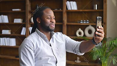 African-American male office employee using a phone for video call