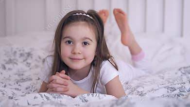 Barefoot girl resting on bed
