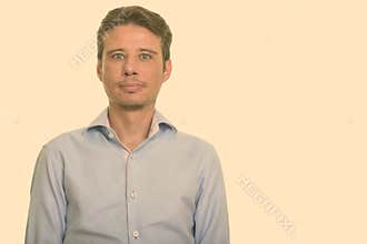 Portrait of handsome Caucasian man shot against plain studio background