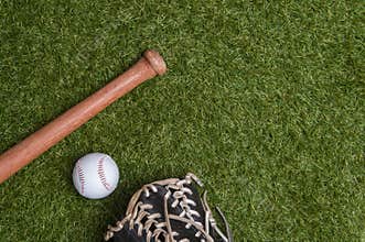 Baseball bat, glove and ball on green grass field.  Sport theme background with copy space for text and advertisment