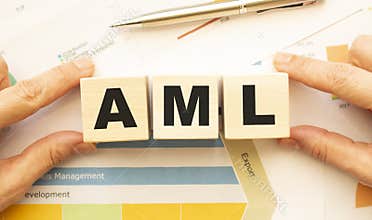 Cropped view of hands holding wooden cubes with AML lettering on work table