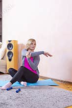 Distant Training Ideas. Tranquil Mature Female While Exercising On Blue Mat During Session At Home