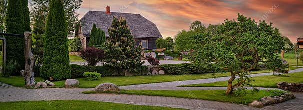 beautiful landscaped garden in front of old wood house. banner
