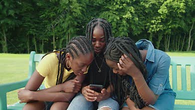 Lovely african teenage girls watching social media content online on phone