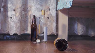 An empty bottle rolls on the floor