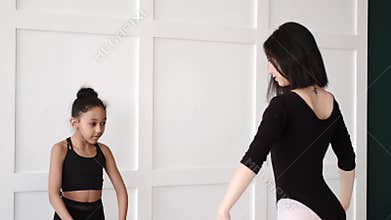 Woman teaching African girl how to dance ballet