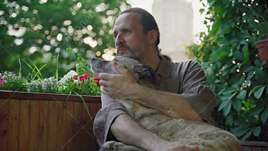 A handsome bearded gentle middle-aged man hugging his dog
