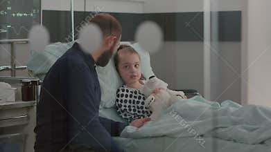 Father holding sick daughter hand explaining medication treatment against medical sickness