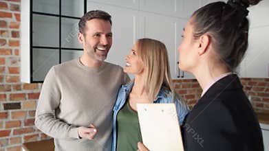 Close up video of realtor giving house keys to couple.