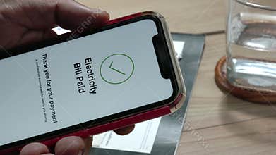 Hand of confused senior man trying pay electric bill on cellphone