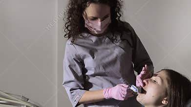 The orthodontist using dental impression tray on woman teeth. Dental spatula with print for dental implant