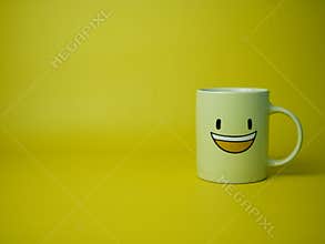 yellow coffee mug with smile emoticon icon.