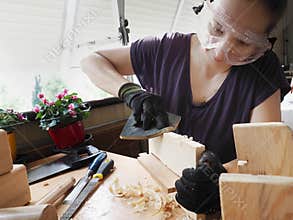 A woman doing wooden handicraft in the balcony