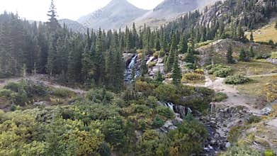 Aerial through amazing mountain valley towards multiple waterfalls