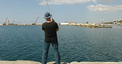 Mid adult man fishing at Aegean sea in Greece
