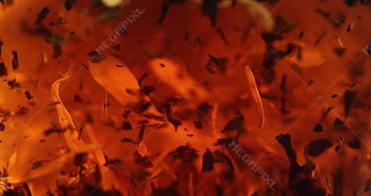 Close-up of brewing of black tea. Macro shot of tea leaves floating in boiling water in transparent glass tea pot. Slow