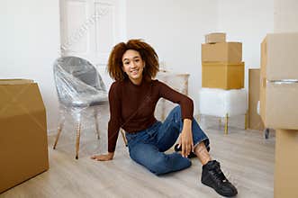 Woman sitting among carton boxes with beginnings