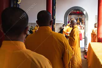 Activity of the monks while praying together in the temple in front of the altar