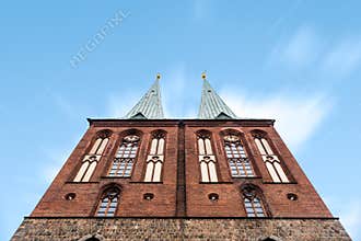 Low angle view of St. Nicholas Church towers against sky. Cloudy day of summer in Berlin