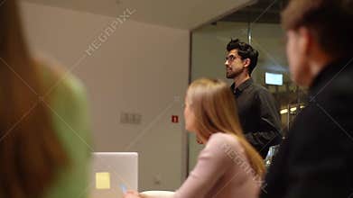 Professional male speaker giving corporate presentation for businesspeople in office, presents new business plan