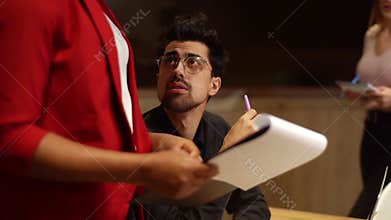 Serious businessman team leader analyze business documents talking discussing project, woman secretary brings folder