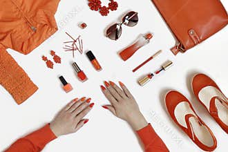 Women& x27;s hands with manicure and items of women& x27;s clothing and accessories.