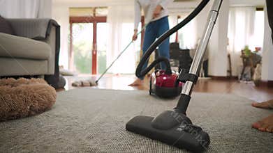 Happy young couple of woman cleaning carpet with vacuum cleaner machine and man mopping the floor at modern home