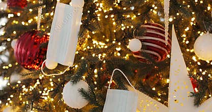 Christmas tree in 2020 decorated with festive lights, balls and medical masks.